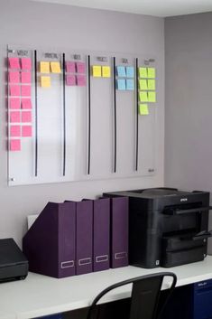 the office desk has several file folders on it, along with a printer and other office supplies