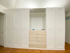 an empty closet with white doors and drawers