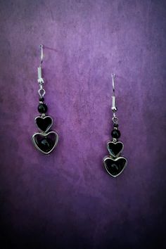 Introducing our stunning Gothic Black Heart Dangle Earrings! These captivating earrings are the perfect accessory for those with a dark and mysterious edge. Crafted with exquisite attention to detail, each earring features a beautifully intricate black heart design, symbolizing passion and intensity. These earrings are lightweight and comfortable to wear, ensuring you can showcase your unique style all day long. Whether you're dressing up for a Gothic-inspired event or simply want to make a statement, these earrings will add a touch of allure and sophistication to any ensemble. Embrace your inner darkness with our Gothic Black Heart Dangle Earrings and let them be a reflection of your unique personality. Each product is one of a kind so there might be slight variations in colour, thickness Dark Feminine Earrings, Black Metal Jewelry For Valentine's Day, Black Sterling Silver Heart Earrings, Valentine's Day Black Metal Jewelry, Black Heart-shaped Pierced-style Jewelry, Black Dangle Jewelry For Valentine's Day, Gothic Metal Earrings For Valentine's Day, Elegant Black Metal Heart Earrings, Black Heart Earrings As A Gift