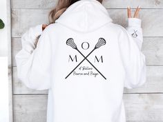 Stay warm and stylish on game day with our custom Lacrosse Mom Hoodie, the perfect gift for proud lax mamas! 🥍 This cozy sweatshirt not only showcases your love for the sport but can also be personalized with your kids' names for a special touch. 💕 Whether you're cheering from the sidelines or running errands, our Lacrosse Mom Sweater with a unique sleeve design is a must-have for any lacrosse team mom. Treat yourself or surprise a fellow lax mama with this custom lacrosse gift, ideal for Moth White Hooded Hoodie For Team Events, White Long Sleeve Hoodie For Team Events, Customizable Sports Hoodie, Customizable Long Sleeve Sports Hoodie, Customizable Sporty Hoodie For Sports, Mom With Kids, Team Mom Gifts, Lacrosse Gifts, Lacrosse Team