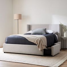 a bedroom with a bed, night stand and rug