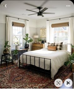 a bed room with a neatly made bed and a ceiling fan in the middle of it