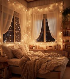 an unmade bed in front of a window with fairy lights