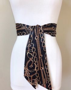 "Wide Black & Gold Chain Sash Belt Black and Gold Sash Gold Chain Link Belt Chain Link Sash Black and Gold Dress Sash Satin Swank Instantly update your jeans, dress, or top with this Satin Swank® black and gold chain print sash belt. Depending on your waist size and the length you choose (60, 75, and 90 inch lengths available), you can wrap this sash around your waist once or twice. You decide whether to tie the sash in a bow or a simple knot with long-hanging tails. Tie in front, in back, o Elegant Black Belt For Night Out, Elegant Black Party Belt, Black Chain Belt For Party, Elegant Black Belt For Evening, Chic Black Chain Belt For Party, Chic Black Adjustable Chain Belt, Chic Black Belt For Party, Elegant Party Chain Belt With Chain Print, Elegant Chain Print Belt For Party