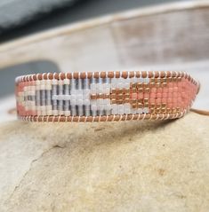 a beaded bracelet sitting on top of a rock