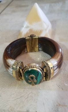 Subscribe to our newsletter NOW: http://eepurl.com/dEBXqb. BUY today and save 10% off all purchases of $50 or more (NEXTORDER10), plus free shipping within the USA!  This is it. Gorgeous Egyptian-inspired jewelry. This unique horn bone bracelet has a beautiful bronze-plated lead-free pewter ankh pendant on a Malachite crystal stone. This item will add a touch of ancient Egypt to your outfit.  The ancient Egyptian symbol - Ankh. The Ankh is the key to life, the legend of the Nile. It represents the concept of eternal life, which is the general meaning of the symbol.  With the wisdom of the Malachite crystal, progress isn't measured in material riches but with spiritual treasures found deep within the heart. But this enchanting stone also has a practical side. The Malachite meaning brings us