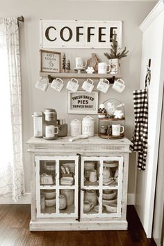 a coffee bar with cups and mugs on the top, next to a sign that says coffee