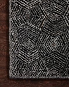 a black and white rug on top of a wooden floor