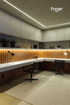 an office with two desks and chairs in front of a wooden paneled wall