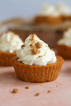 small cupcakes with white frosting and cinnamon sprinkles on top