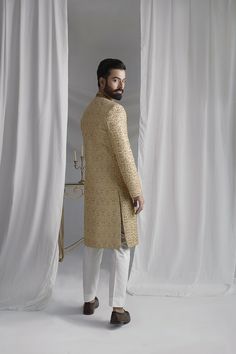 Discover the timeless elegance and regal charm of our Collar Detail Gold Sherwani. Made from pure atlas material, this sherwani features exquisite hand-embroidered jal work of resham, zardozi, Swarovski stones, and dabka. Complete with a jamawar kula (turban) and silk inner kurta pajama, this resplendent piece is perfect for any special occasion. Elevate your style with this luxurious and sophisticated sherwani. 4-Piece Suit Elegant Sherwani With Zari Work Straight Kurta, Elegant Sherwani With Zari Work, Elegant Long Gold Sherwani, Traditional Gold Sherwani With Straight Kurta, Gold Sherwani With Zari Work In Straight Kurta Style, Gold Sherwani With Zari Work, Elegant Designer Wear Sherwani With Straight Kurta, Ceremonial Straight Kurta Sherwani With Dabka Work, Gold Sherwani With Zari Work For Designer Wear