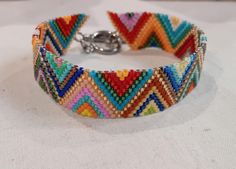 a bracelet made with multicolored beads on a white tablecloth, close up