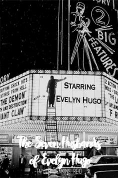 a black and white photo of a man standing on top of a movie marquee