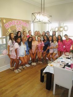 a group of young women standing next to each other in front of a sign that says home coming girls