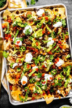 a tray filled with taco salad and tortilla chips on top of a table