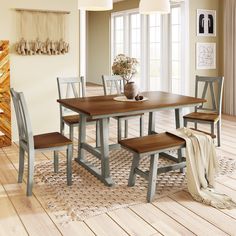 a dining room table with four chairs and a bench in the middle on a wooden floor