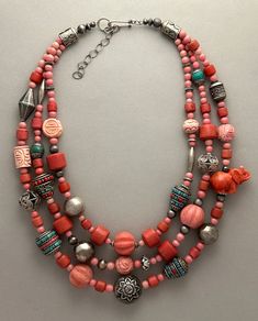 One-of-a-kind handcrafted statement necklace. Beads: 3 strands of Tibetan faux coral (glass), carved coral and glass, antique and sterling silver Dimensions: approximately 24" + 2.5" extender Make a statement with this delightful necklace! Free Shipping Refund Policy Unique Coral Beaded Necklaces With Round Beads, Unique Coral Beaded Necklace With Round Beads, Unique Coral Beaded Necklaces, Multi-strand Red Coral Beaded Necklaces, Coral Multi-strand Beaded Necklaces, Coral Multi-strand Beaded Necklace, Coral Red Multi-strand Beaded Necklaces, Coral Bohemian Polished Beads, Coral Beaded Multi-strand Necklace