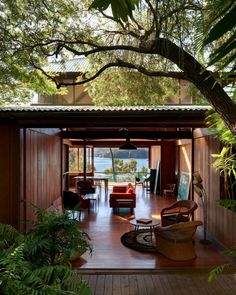 the inside of a house with wooden floors and lots of greenery on the outside