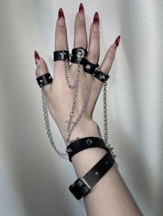 This uniquely designed bracelet features an integrated ring, connected by a stylish chain that adds a touch of avant-garde elegance. The bracelet is adorned with stud embellishments, while the ring showcases intricate decorations including skeleton motifs, crosses, and additional studs.  Please note that the price includes one bracelet with rings.  Ring Diameters: - Thumb, Index, and Middle Fingers: 6.5 cm - Ring and Pinky Fingers: 6 cm Party Jewelry With Metal Decoration, Emo Jewelry With Adjustable Chain For Parties, Edgy Adjustable Metal Chain Bracelet, Edgy Style Bracelet Jewelry, Emo Style Party Jewelry With Chain, Adjustable Edgy Metal Chain Bracelet, Emo Party Jewelry With Chain, Adjustable Metal Ring With Chain Detail, Adjustable Chain Ring In Metal