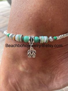 This beautiful beach ankle bracelet for women is made with green stone beads, white and green shell beads, silver Tibetan beads, a silver flip flop charm, and silver glass beads. Don't like the flip flop charm? I have several to choose from. Just message me your preference and I'll see what I can do for you! Ankle bracelet comes in several sizes, just choose your size from the drop down menu at checkout. Don't see your size? Just message me and I'll be happy to make your size for you! Adjustable Silver Beaded Bracelets For Beach, Bohemian Silver Beaded Bracelets For Beach, Adjustable Silver Anklets For Beach Season, Adjustable Silver Anklets For Vacation, Silver Beaded Bracelets With Tiny Beads For Beach, Silver Adjustable Anklets For Vacation, White Round Beads Anklets For Vacation, Silver Strand Bracelets For Summer, Bohemian Green Jewelry For Beach Season