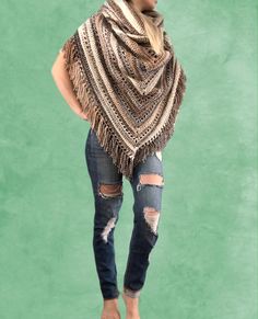 a woman in ripped jeans and a ponchy shawl