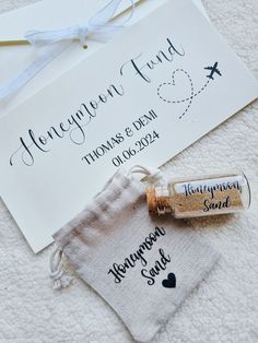 two personalized wedding favors are sitting on a towel next to an envelope and wine bottle