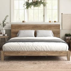 a bed with white sheets and pillows in a room next to a window, potted plants on the wall