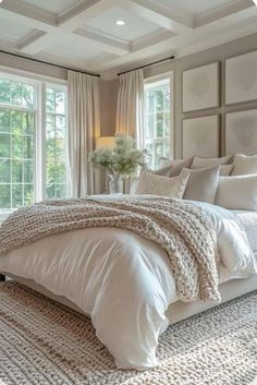 a large white bed sitting in a bedroom next to two windows