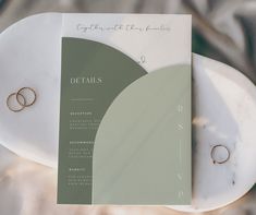 two wedding rings sitting on top of a menu