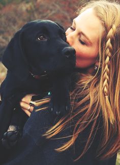 a woman is kissing her dog on the nose with an instagramr above her