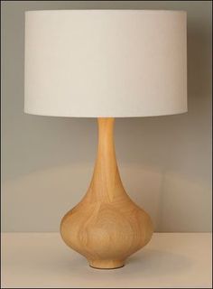 a wooden table lamp with a white shade