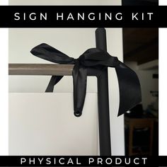 a sign hanging kit with a black bow on it's side and the words physical product written below