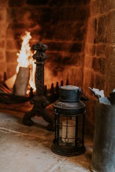 an old fashioned lantern sitting in front of a fire place