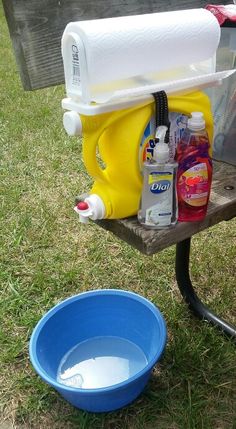 a blue bucket sitting on top of a wooden bench next to a yellow and white cooler