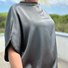 Elevate your wardrobe with our stunning lustrous grey satin top, designed in a loose-fit style. Fold the hem up over your hips or tucked into a pair of pants or a skirt. Whether it's a day at the office, a night out with friends, or a romantic date, this top adds an elegant touch to any occasion. Crafted from a luxurious heavyweight satin, it drapes beautifully, offering effortless sophistication with every movement Proudly made in Izmir Turkey by Kopenhag Studio Good to know The model is 5'6" and wears a small Ecovero from Lenzing is a sustainable vegan silk made from responsibly sourced wood pulp. Handwash inside out or wash inside out on cold Sleek Evening Top With Satin Finish, Sleek Satin Finish Top For Evening, Sleek Satin Finish Evening Tops, Sleek Satin Finish Tops For Night Out, Sleek Satin Finish Top For Night Out, Sleek Metallic Tops For Night Out, Sleek Sheen Party Top, Sleek Tops With Sheen For Night Out, Sleek Party Tops With Sheen Detail