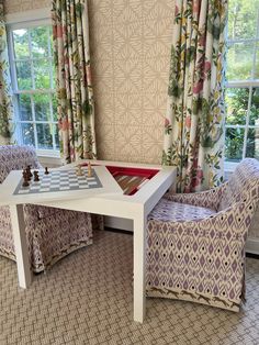 a living room filled with furniture and a chess board on top of a white table