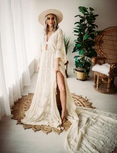 a woman in a white dress and hat standing on a rug next to a window