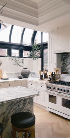 a kitchen with marble counter tops and an island in front of a stove top oven