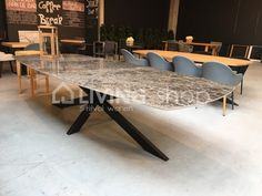 a large marble table with blue chairs around it