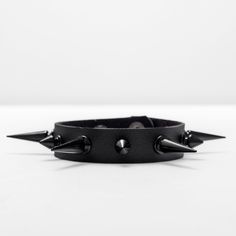 This bracelet measures 9 inches long and 1 inch wide, and is crafted from black, supple leather for maximum comfort. The adjustable metal button buckle allows for a customizable fit. Adorned with 4 large, glossy black alloy metal studs that protrude 1 inch, as well as 3 smaller studs made from the same luxurious material. Spike Bracelet, Bracelet Collection, Elevate Your Look, Metal Buttons, Alternative Fashion, Leather Straps, 1 Inch, Buckle, Bracelet