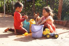 two children playing with toys in the dirt