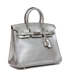 This Ultra Rare Birkin is in Silver metallic chevre leather with palladium hardware and has tonal stitching, front flap, two straps with center toggle closure, clochette with lock and two keys and double rolled handles.The interior is lined with black chevre and has a zip pocket with an Hermes engraved zipper pull and an open pocket on the opposite side. Collection: H squareOrigin: FranceCondition: ; Mint- the bag retains its structure. The metallic leather shows some light wear noticeable upon close inspection. There is plastic on the hardware. The inside is clean with light pressmarks. Accompanied by: Hermes box, Hermes dustbag, clochette, lock, two keys, clochette dustbag, rainhat, carebook, ribbon and feltMeasurements: 10" width x 7.5" height x 4.75" depth; 2.75" handle drop Rare Birkin, Hermes Birkin 25, Hermes Box, Birkin 25, Madison Avenue, Sierra Leone, Hermes Birkin, Metallic Leather, New Bag