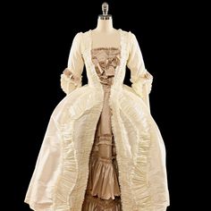 A Rococo Style gown made from polyester dupioni. The gown features an abundance of ruffles, made from the same fabric as the gown and strategically placed to add volume and movement to the dress. The separate underskirt is also decorated with ruffles and will provide additional volume and texture to the overall look of the gown. The sack back drapes elegantly over the back and hips and creates a soft, flowing silhouette.This dress can be made in many different color combinations. The front of th Couture Gown With Ruffles And Fitted Bodice, Couture Gown With Fitted Bodice And Ruffles, Taffeta Ball Gown Wedding Dress, Couture Floor-length Ruffled Gown, Couture Evening Dress With Ruffles, Formal Taffeta Gown With Ruffles, Silk Ball Gown With Boned Bodice, Taffeta Gown With Ruffles For Formal Occasions, Satin Victorian Ball Gown With Ruffles