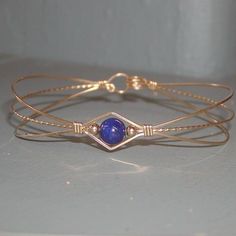 A sweet design of three strands of 14kt gold filled wire featuring a single 6mm genuine lapis bead flanked by two small 14kt gold filled beads. So Metal Wire Bracelet, Adjustable Hand-strung Cuff Bracelet Gift, Adjustable Hand-strung Wrap Bangle, Friendship Hand Wrapped Bangle Bracelet, Dainty Adjustable Wire Wrapped Beaded Bracelets, Adjustable Cuff Bracelet With Round Beads As Gift, Adjustable Round Beads Cuff Bracelet As Gift, Adjustable Cuff Bracelet With Round Beads For Gift, Gift Adjustable Cuff Bracelet With Round Beads