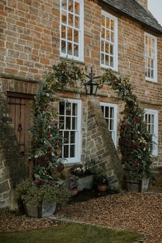 an old brick house with potted plants outside