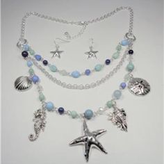 This Beautiful Rhodium Nautical Starfish Seashell Aqua And Blue Beads Sea Life Layered Necklace And Earrings Set Features Aqua, Blue And Rhodium Beads With The Rhodium Sea Horse, Seashells, Sand Dollar And Starfish Charms As Well As Aqua And Blue Beads And Bluish Pearls. The Silver Tone Necklace Is 20 Inches Long With A 2 Inch Extender To 22 Inches And Has A Lobster Claw Clasp For A Secure Fit On Your Neck. The Starfish Pendant Measures 1 1/2 Inches High And 1 1/2 Inches Wide. Cn 5-0032 Adjustable Blue Jewelry With Starfish Charm, Bohemian Blue Jewelry With Starfish Charm, Bohemian Blue Starfish Charm Jewelry, Adjustable Blue Starfish Jewelry, Beach Dangle Beads Jewelry, Blue Necklaces With Starfish Charm And Round Beads, Bohemian Starfish Jewelry With Lobster Clasp, Bohemian Starfish Charm Jewelry For Jewelry Making, Bohemian Starfish Charm Jewelry For Crafting