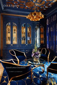 an elegant living room with blue walls and gold trimmings, including two chairs