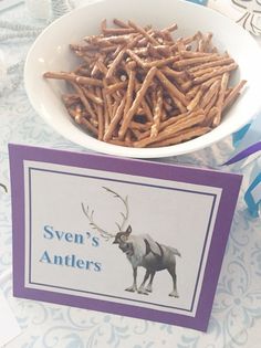 there is a bowl full of sticks next to a card with an animal on it