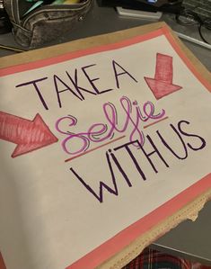 a sign that says take a selfie with us on the side of a desk