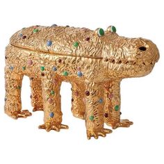 a gold colored animal shaped box with jewels on it